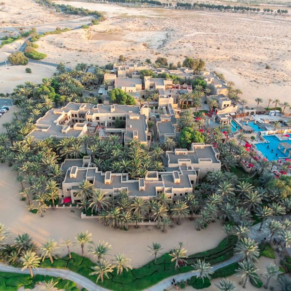 an aerial view of a resort surrounded by palm trees